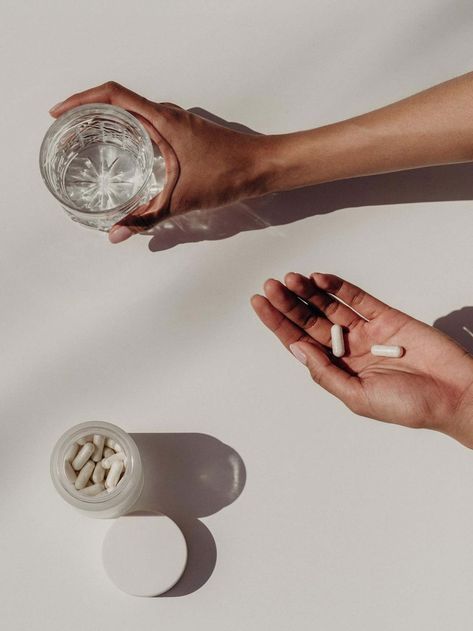 Key 2 Wellness - A woman holds medicine next to a jar of water.